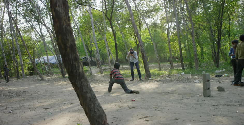 A man photographs children playing sports