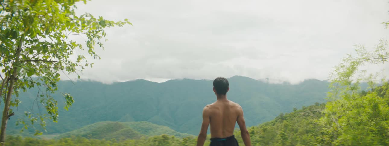 A man runs to the cliff on a cloudy day