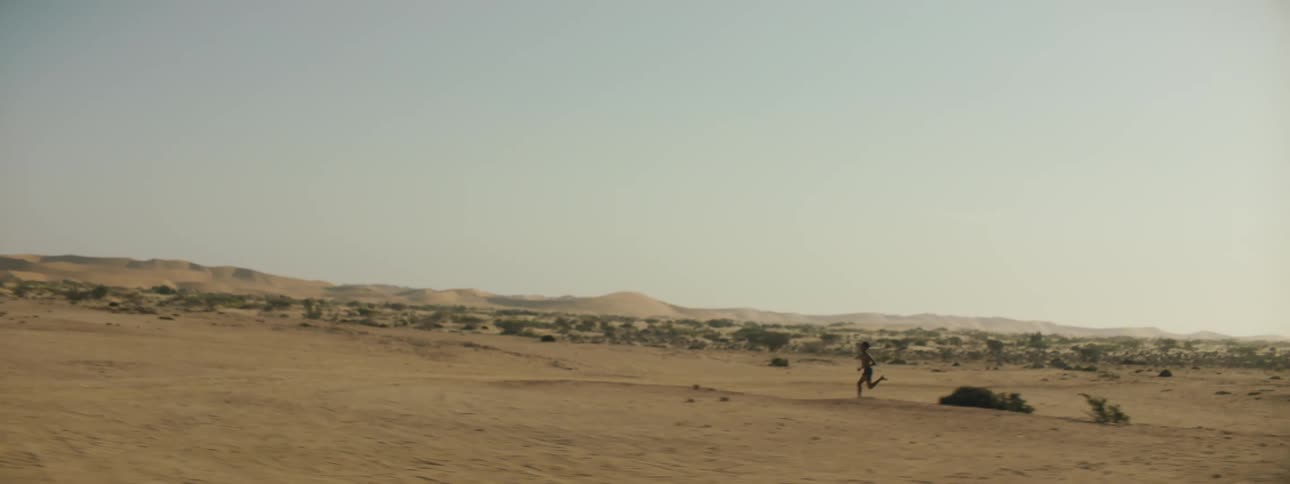Child running through the desert by themselves