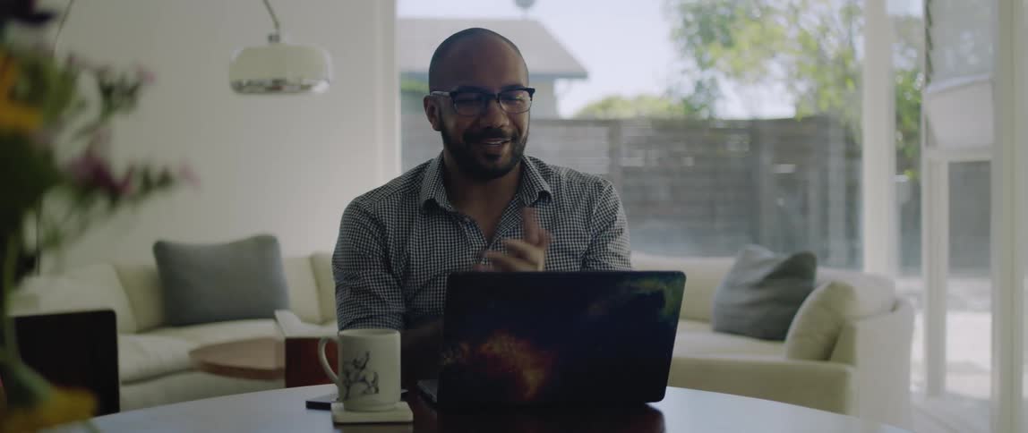 A man talking to someone during a video call on a laptop