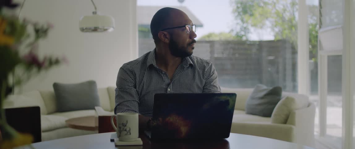 A man works on his laptop in his dining room