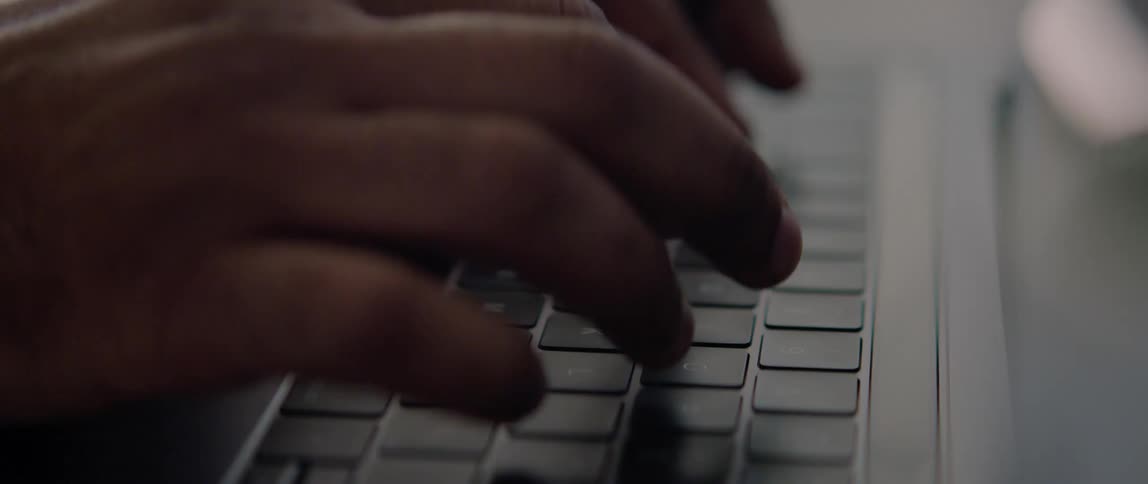 A person types on the keyboard of laptop