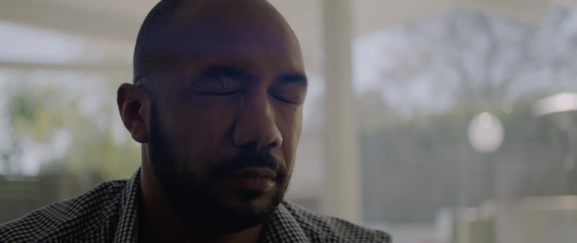 Sitting man takes off his eyeglasses and blinks and closes his eyes while taking a break