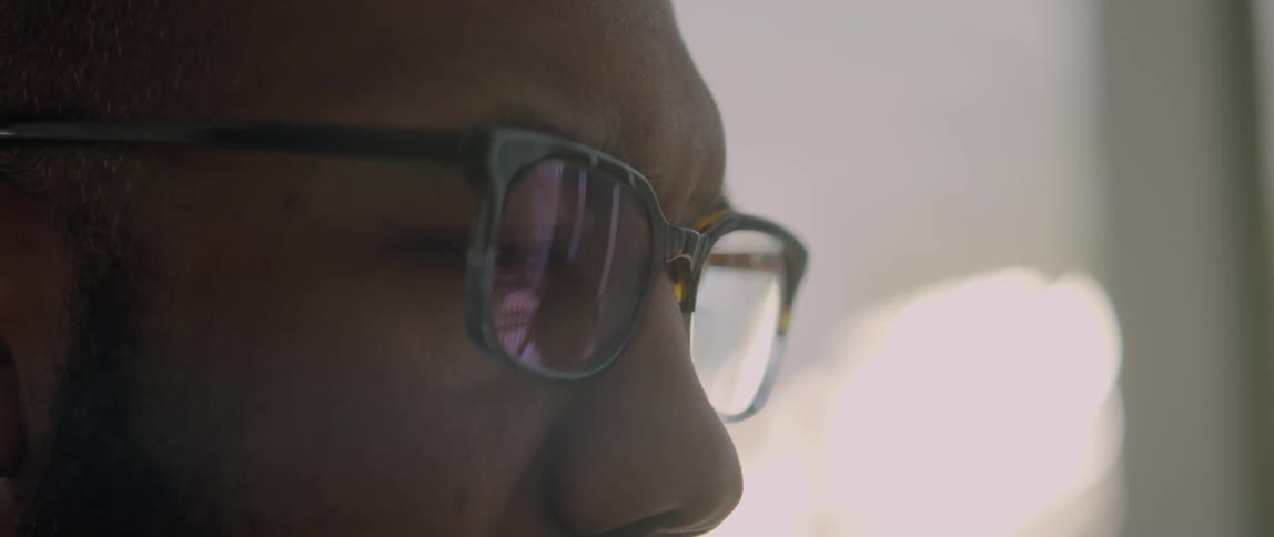 A close up view of a man wearing glasses is displayed