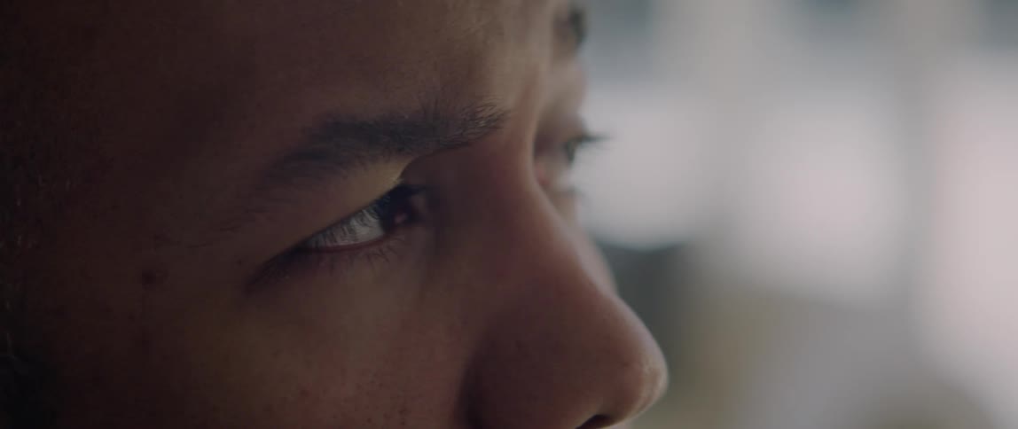 A man blinks a few times while he looks looks off in the distance