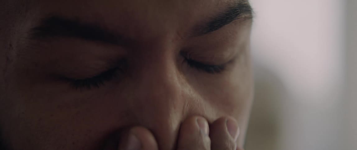 A tired man rubs his eyes with his hand