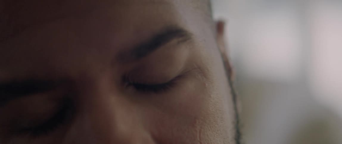 A man closes his eyes and stretches his neck to the side