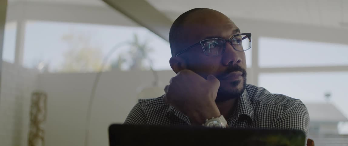 A man sits and thinks and then looks at his computer