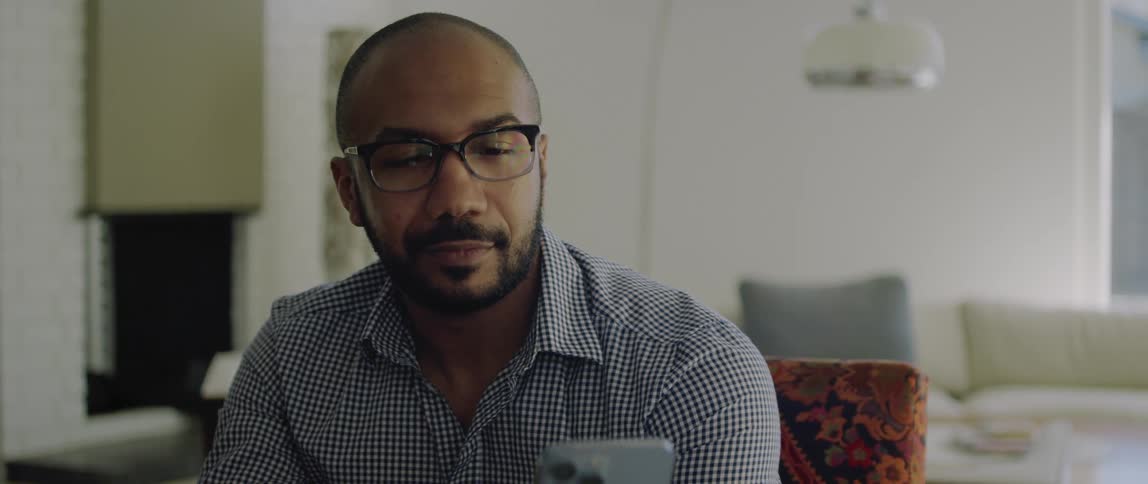 A man is nodding and smiling during a video call on his smartphone