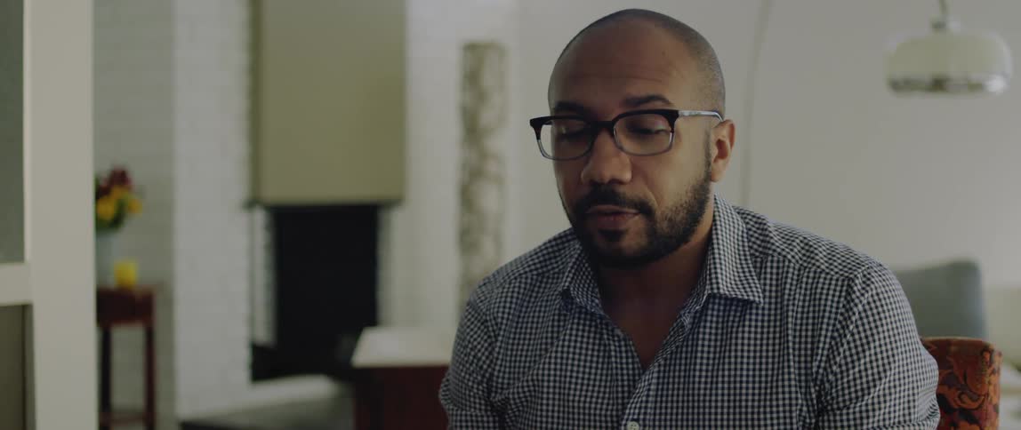 A man chats while sitting at his dining room table