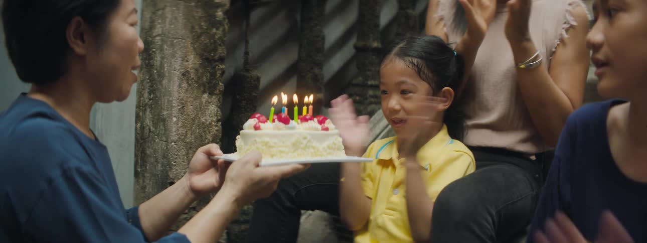 A girl blows out the candles on her birthday cake