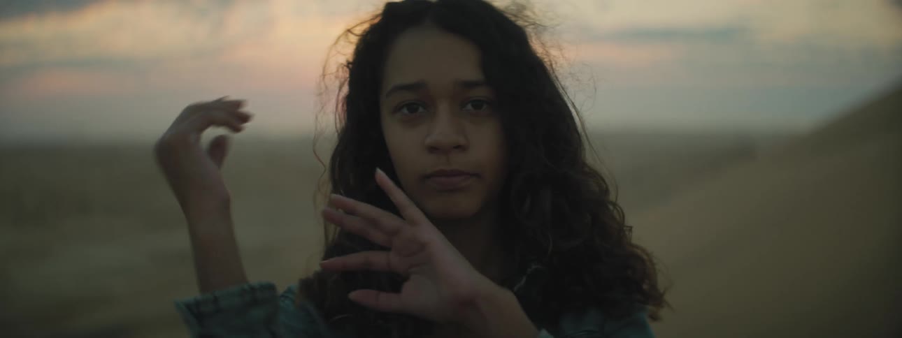 Woman waving her hands at the camera in the desert