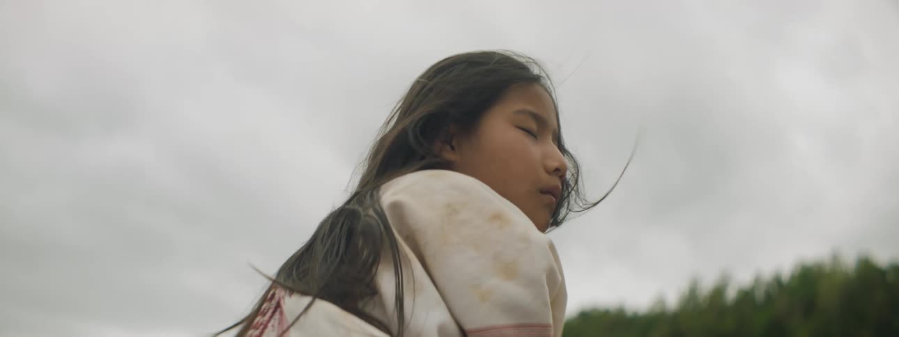 A girl is sitting on a windy day
