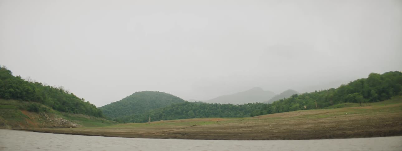 The fields lead to a mountain covered in fog