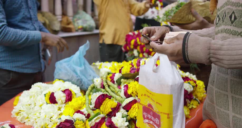 People shop and buy flowers and necklaces