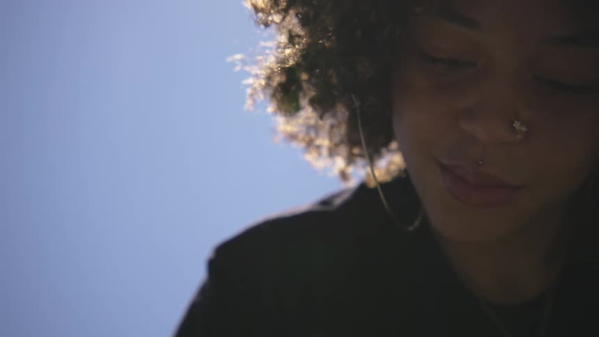A woman with a lot of jewelry is leaning over and swaying