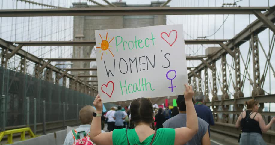 A group marching across a bridge in protest for womens right to choose