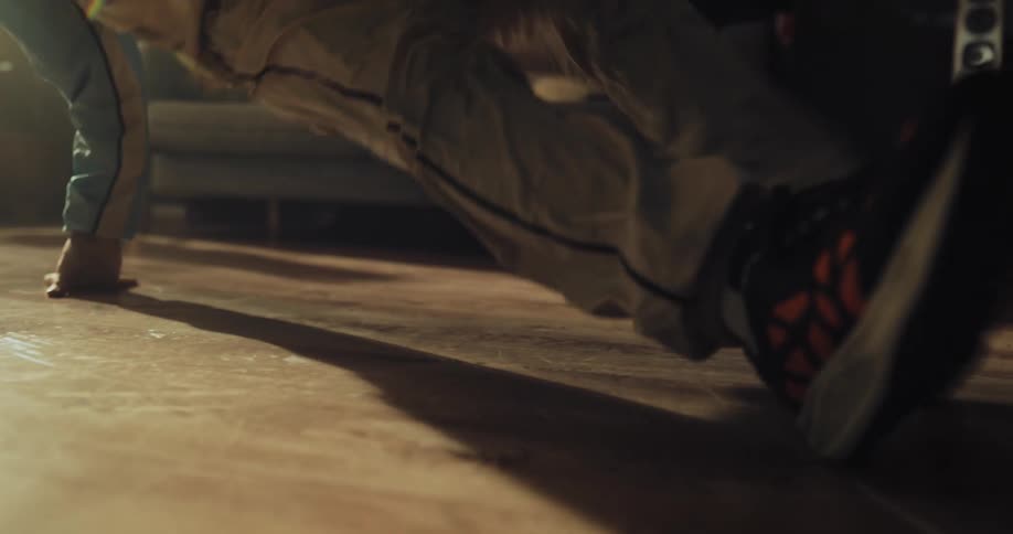 A person breakdances in the living room of a house during the day