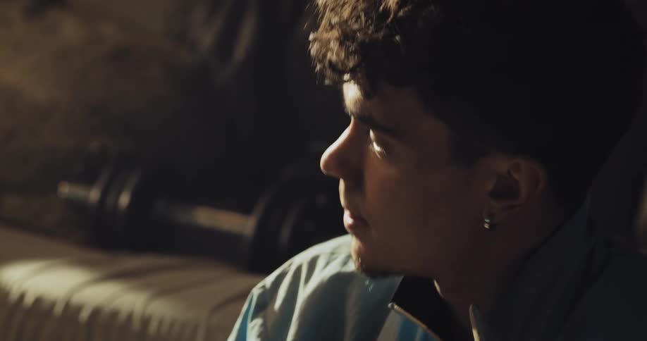 A man exhales deeply while sitting on the floor against a couch