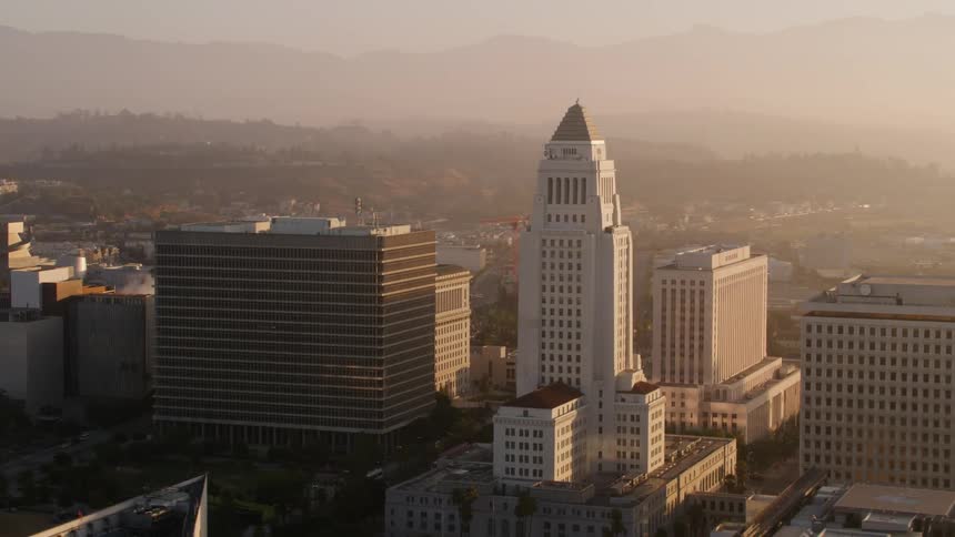A large city surrounded by mountains has heavy smog hanging over it