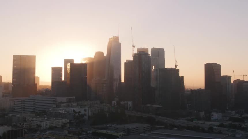 Tall building looming over a freeway in a metropolis in the evening