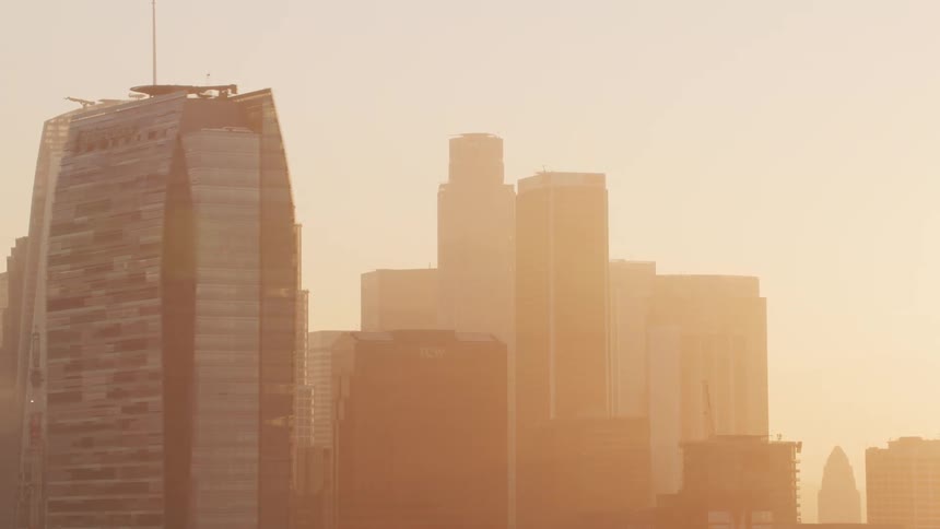 Aerial view of the sunlight behind skyscrapers on the city skyline at morning