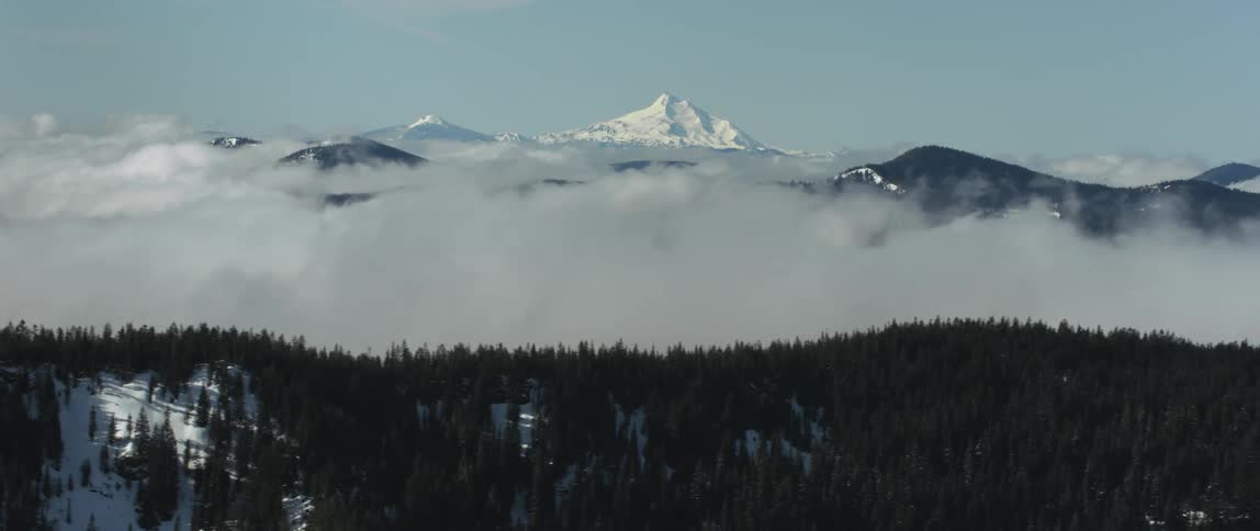A snowy mountainous countryside cover in forest and fog