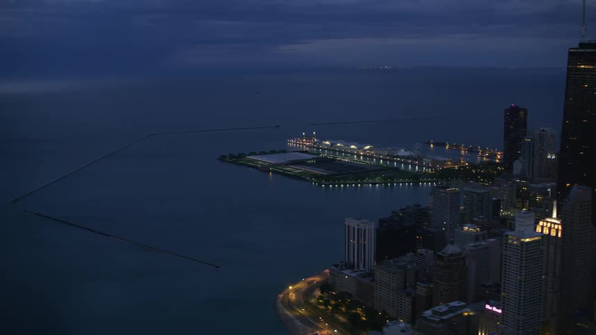 Traffic flows along highway between shore and downtown skyscrapers at night