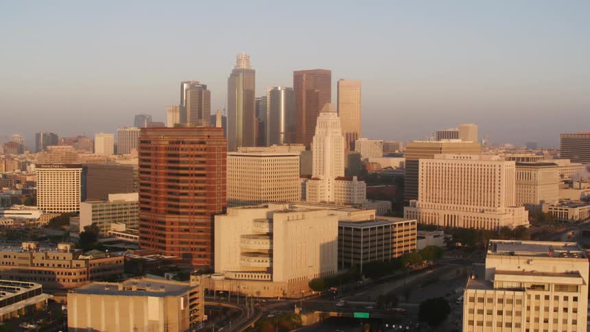 Tall buildings and skyscrapers near a freeway in a metropolis during the day