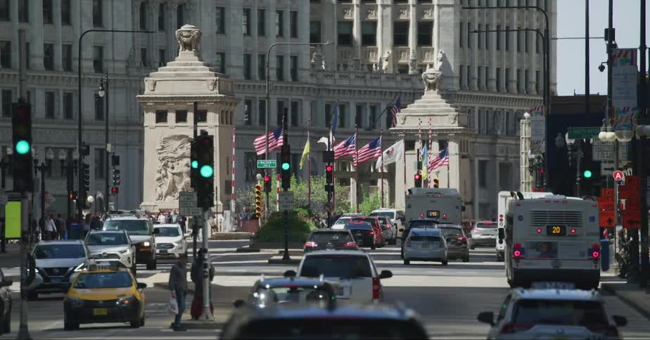 Vehicles driving and people walking in front of a government building