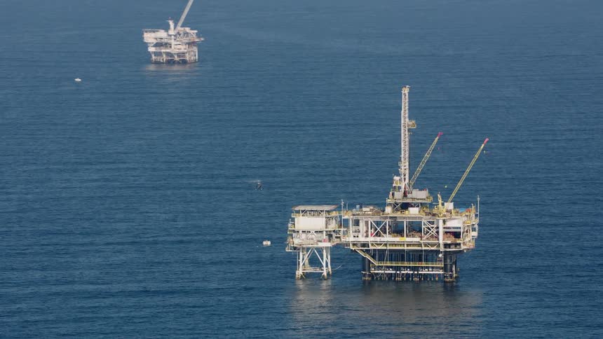 A helicopter comes in for a landing on an oil platform in the ocean