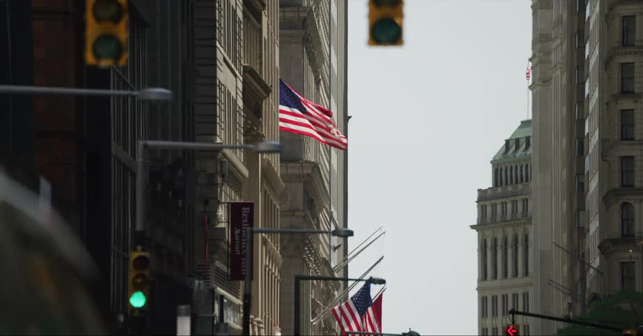 American flag waving on the side of a building in the city