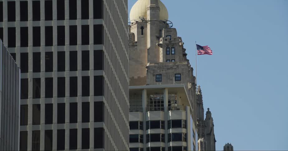 A flag is flying over tall city buildings