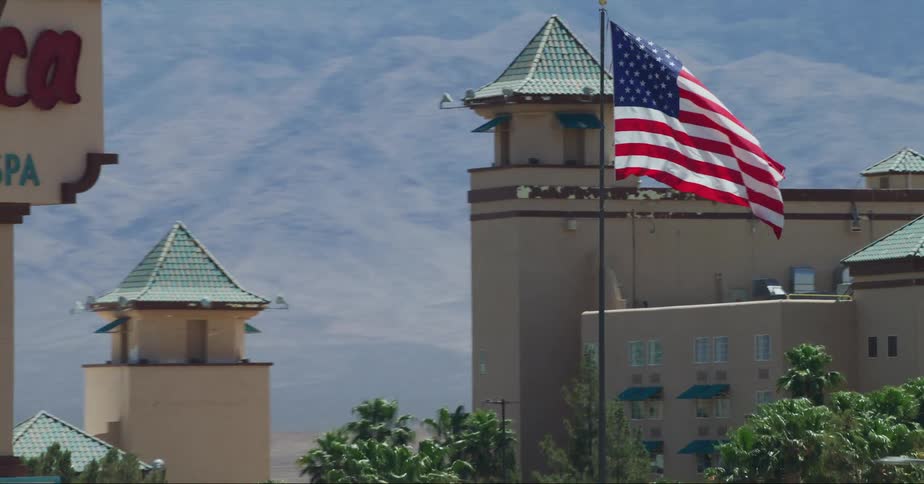 An american flag flutters in the wind outside a casino resort during the day