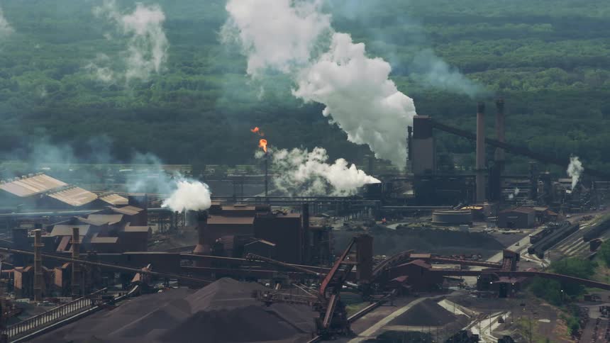 Aerial view of an factory with pollution is displayed