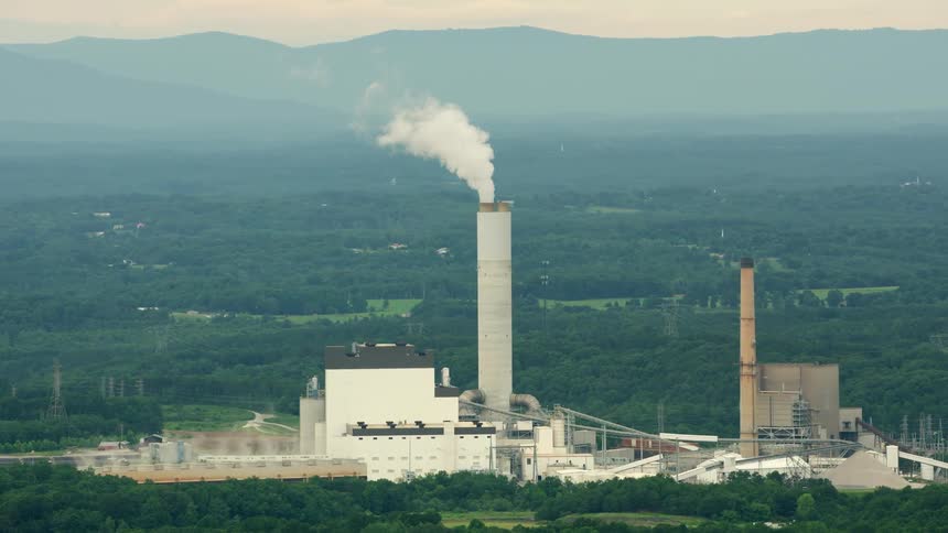 Smoke rises from a tower at a factory