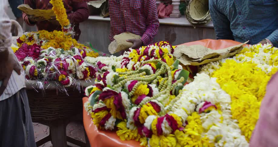Men browsing through garlands of flowers