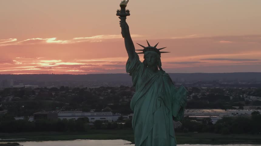 The sun sets over the statue of liberty