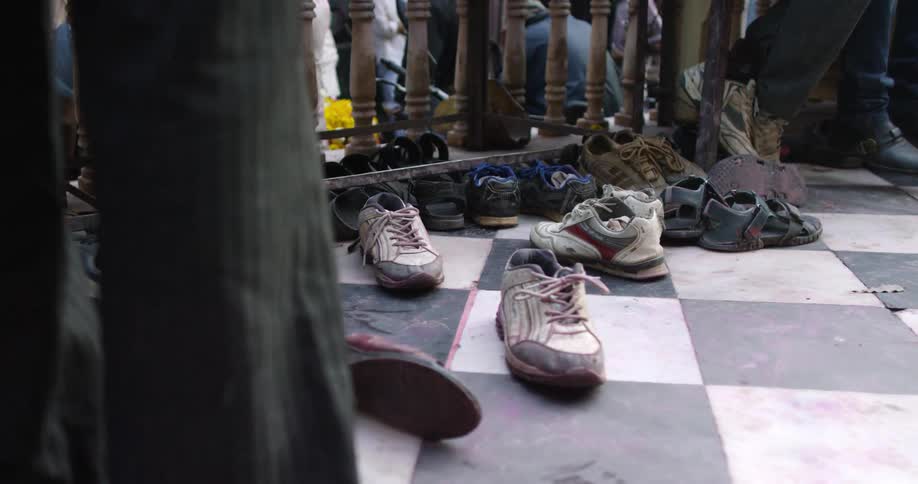 People and shoes lined up near a railing