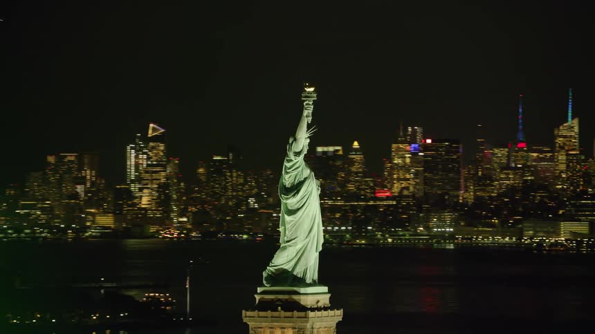 A national statue in a large city is lit up at night