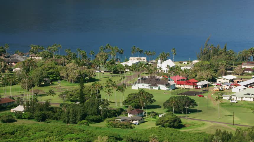 A neighborhood with colorful roofs sits along the coast