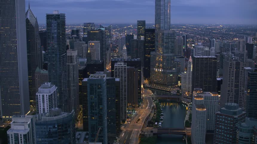 Aerial view of city skyscrapers and buildings at dusk near the river