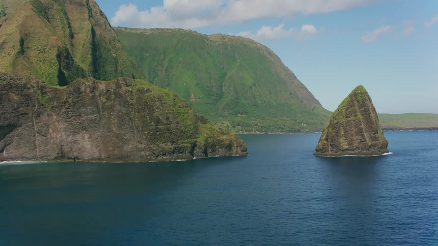 Waves roll past islets and outcroppings to strike shore at base of promontories