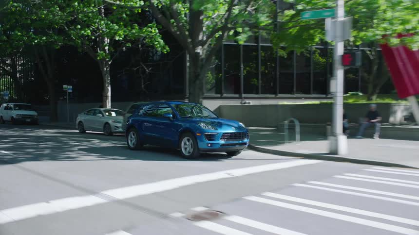 A car is driving on a street in a downtown city