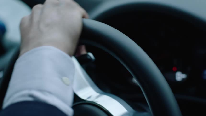 A person is driving a car during the midday