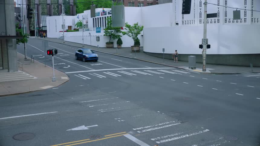 A car travels through an intersection in a city during the day