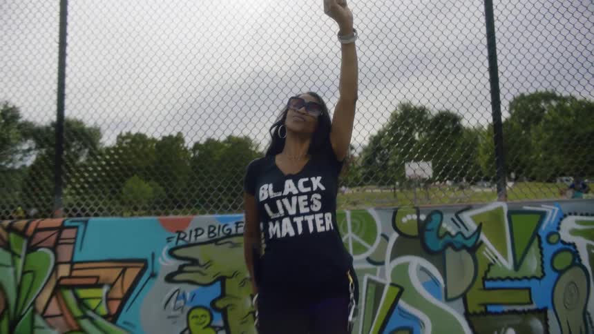 A woman is wearing a black lives matter shirt