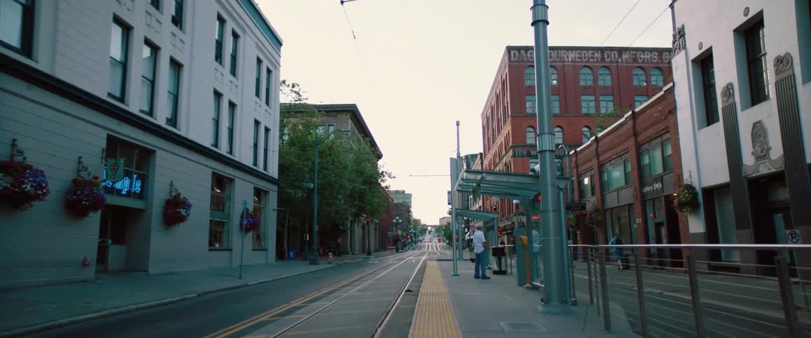 A group of people wait at a bus stop downtown