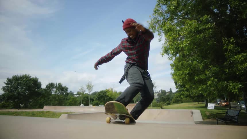 A man rides a skateboard up a ramp in a skate park
