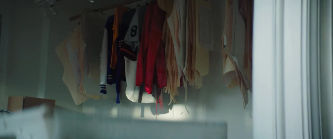 Clothing hangs from a rod in a large closet